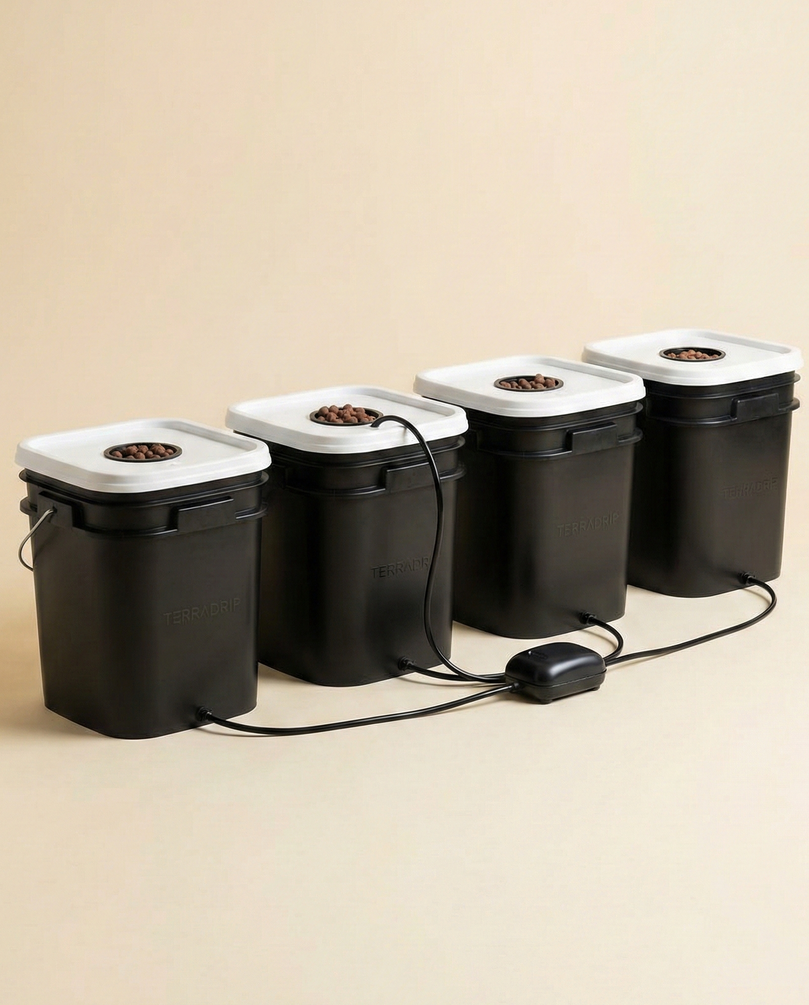 Four premium matte black deep water culture hydroponic buckets with white lids and air tubing on a cream background.