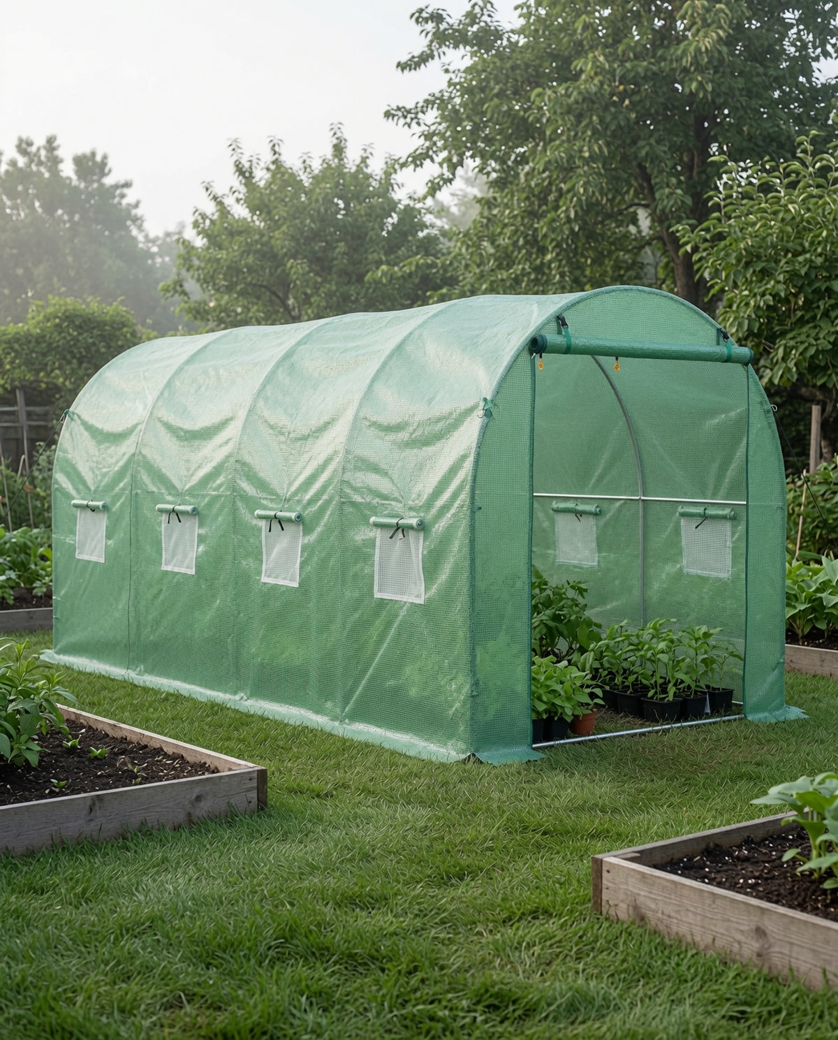 Green walk-in tunnel greenhouse in a backyard garden on a cool misty day with plants visible inside